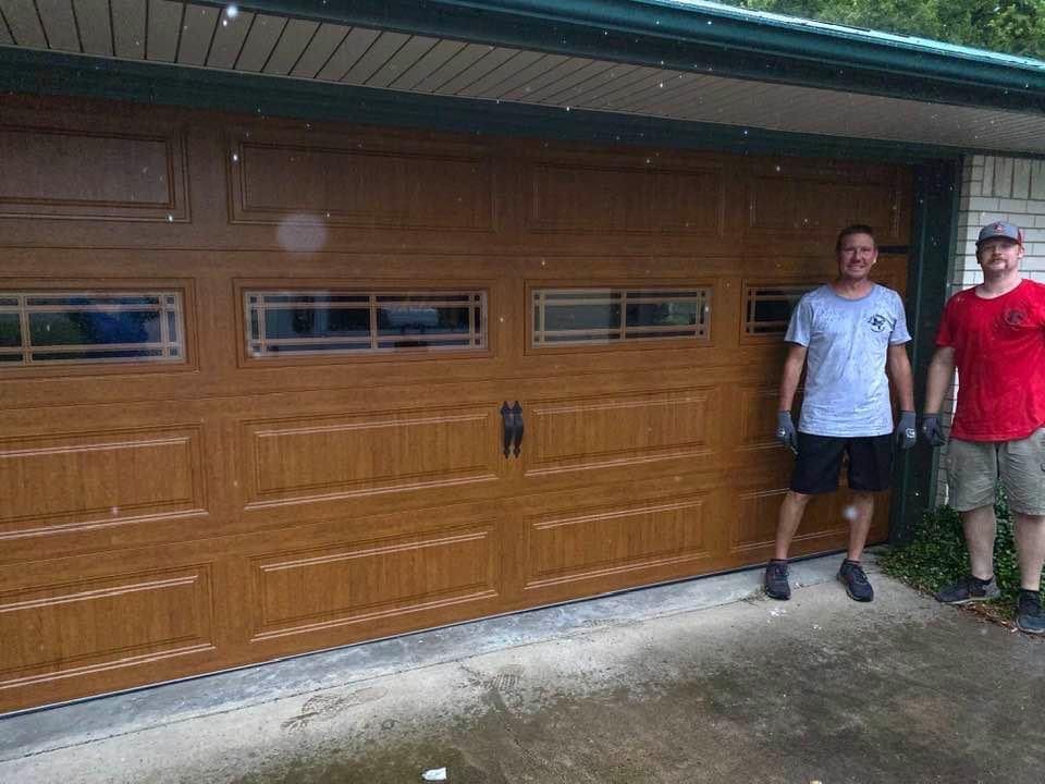 2 Ellis and Parrish Overhead Doors employees in front of completed faux wood garage door installation